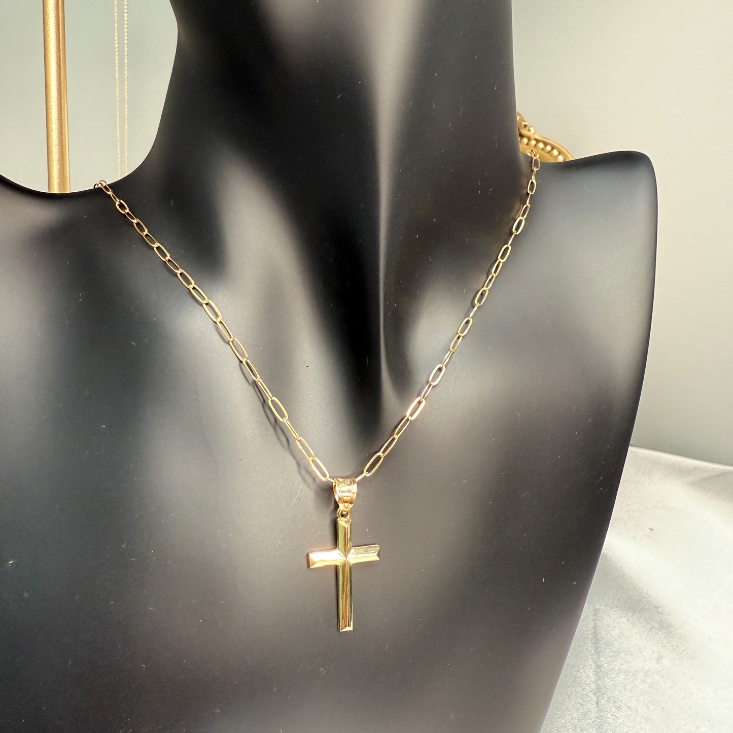 Small 14K double‑bonded gold simple cross pendant high‑polish finish on 16-18" paperclip chain lifestyle image