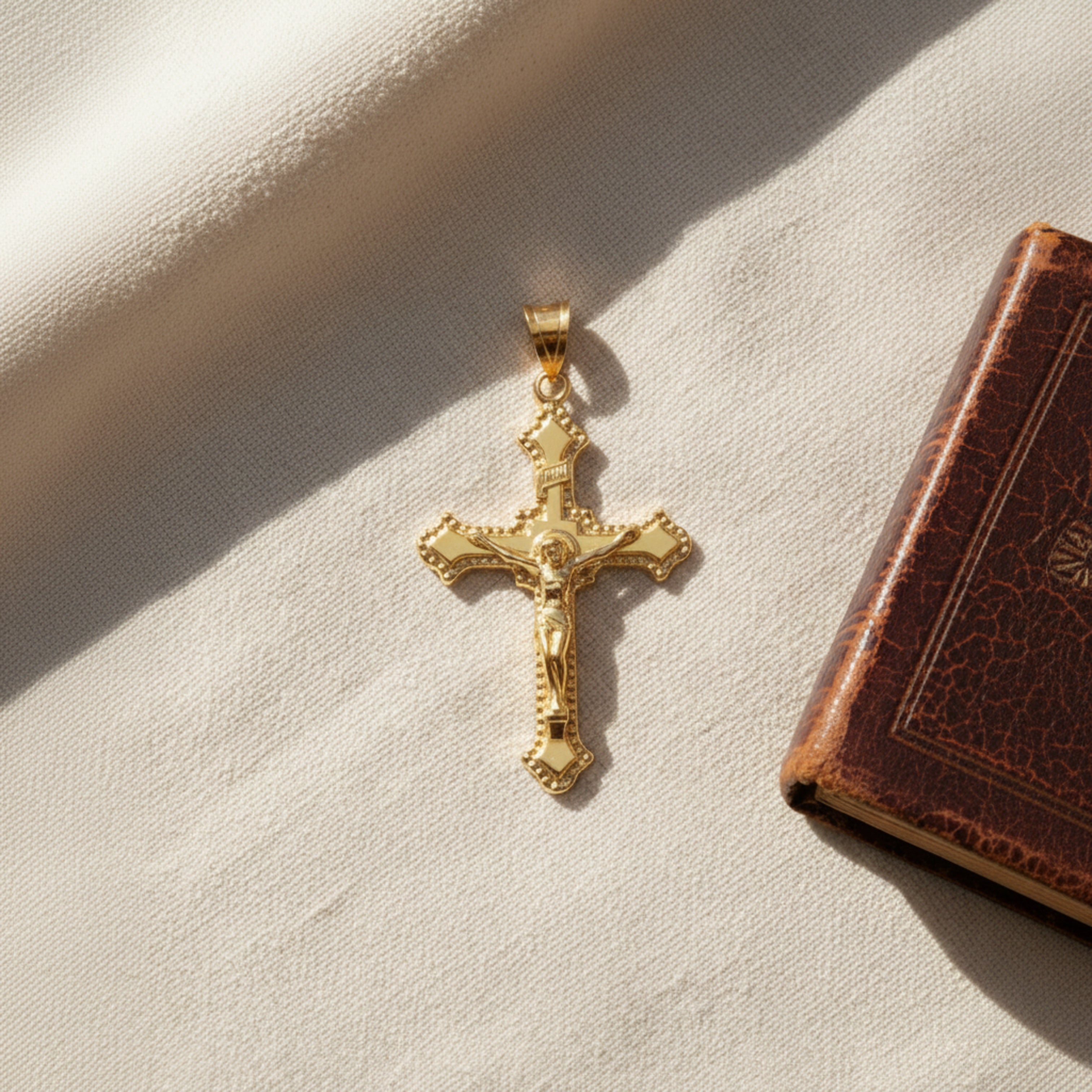 Solid 14K Double Bonded Gold INRI Crucifix XL M size budded edge cross pendant only lifestyle image on cloth next to bible