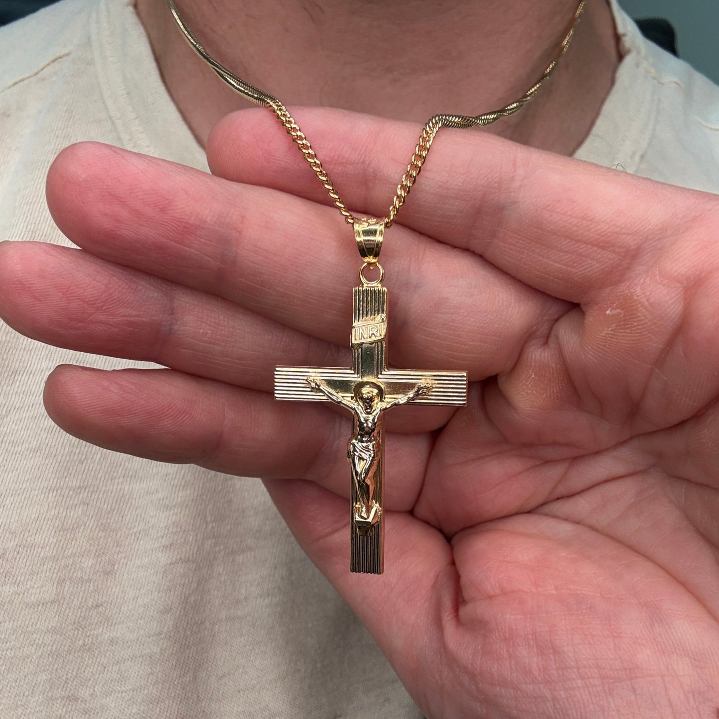 XXL 14K double‑bonded gold INRI crucifix pendant with engine‑turned texture and high‑polish finish on 22" Cable chain lifestyle image