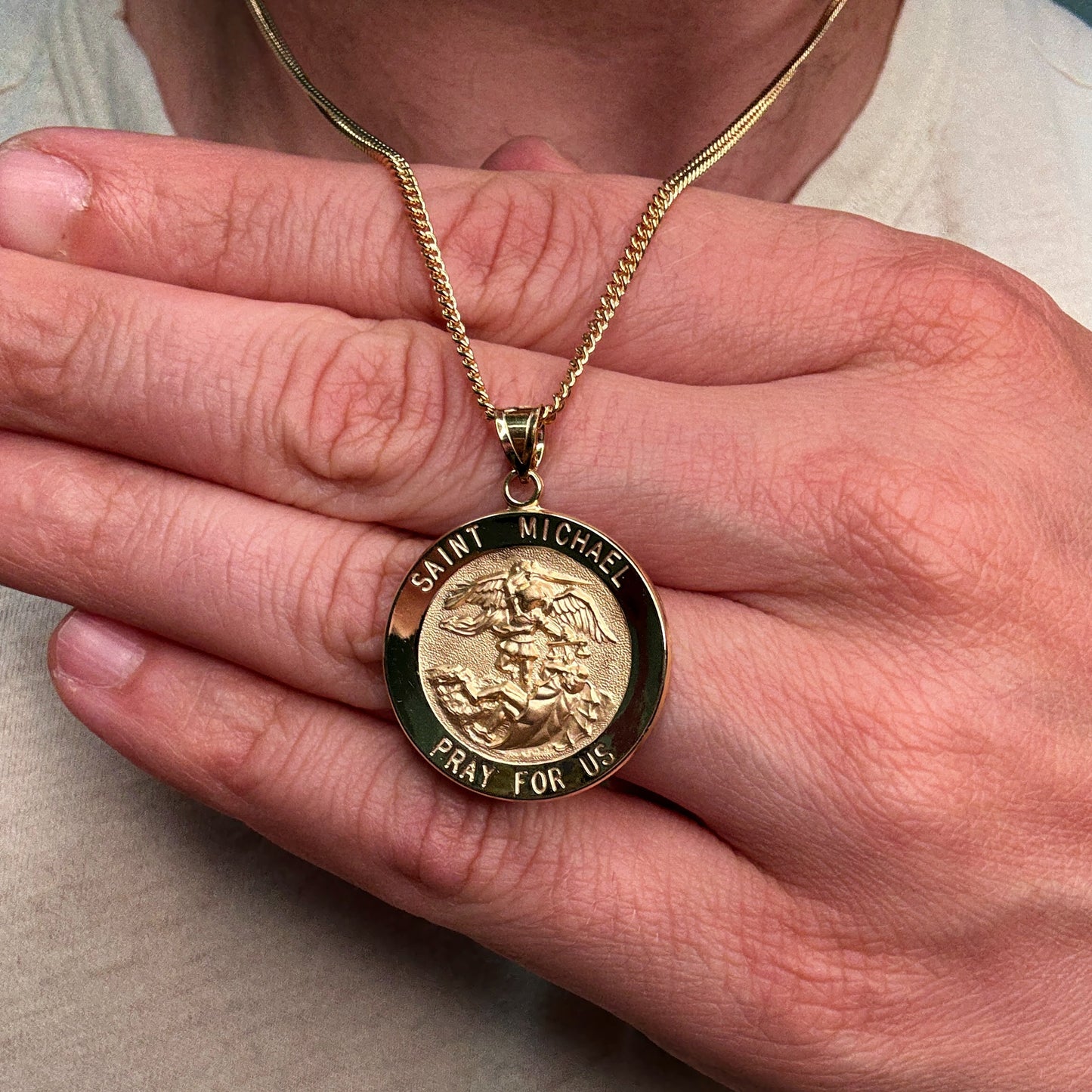 Solid 14K Double Bonded Gold Saint Michael pendant medal XL (size off Quarter) M (size of Dime) on cable chain lifestyle close up image